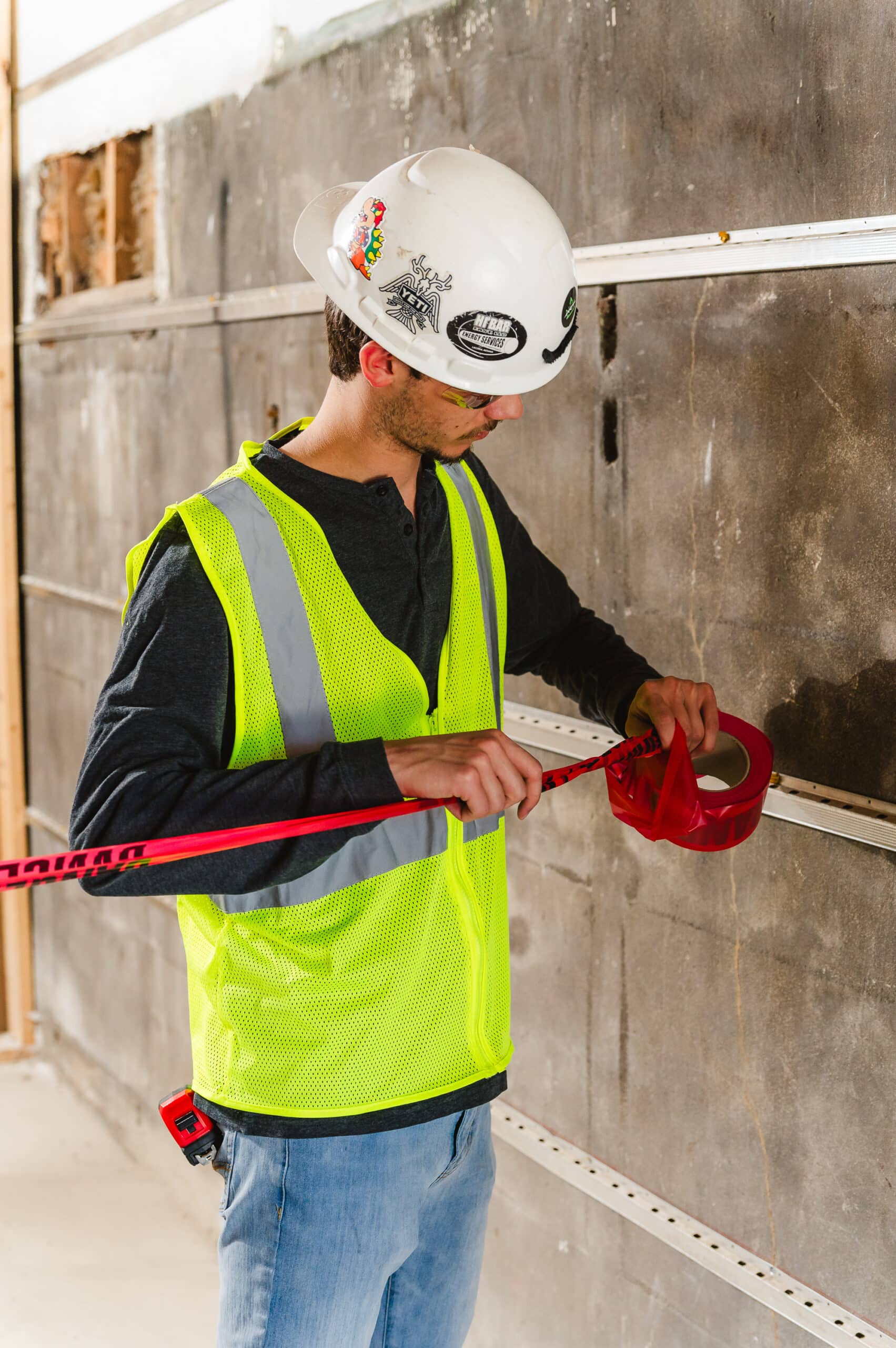 A construction worker hangs hazard tape