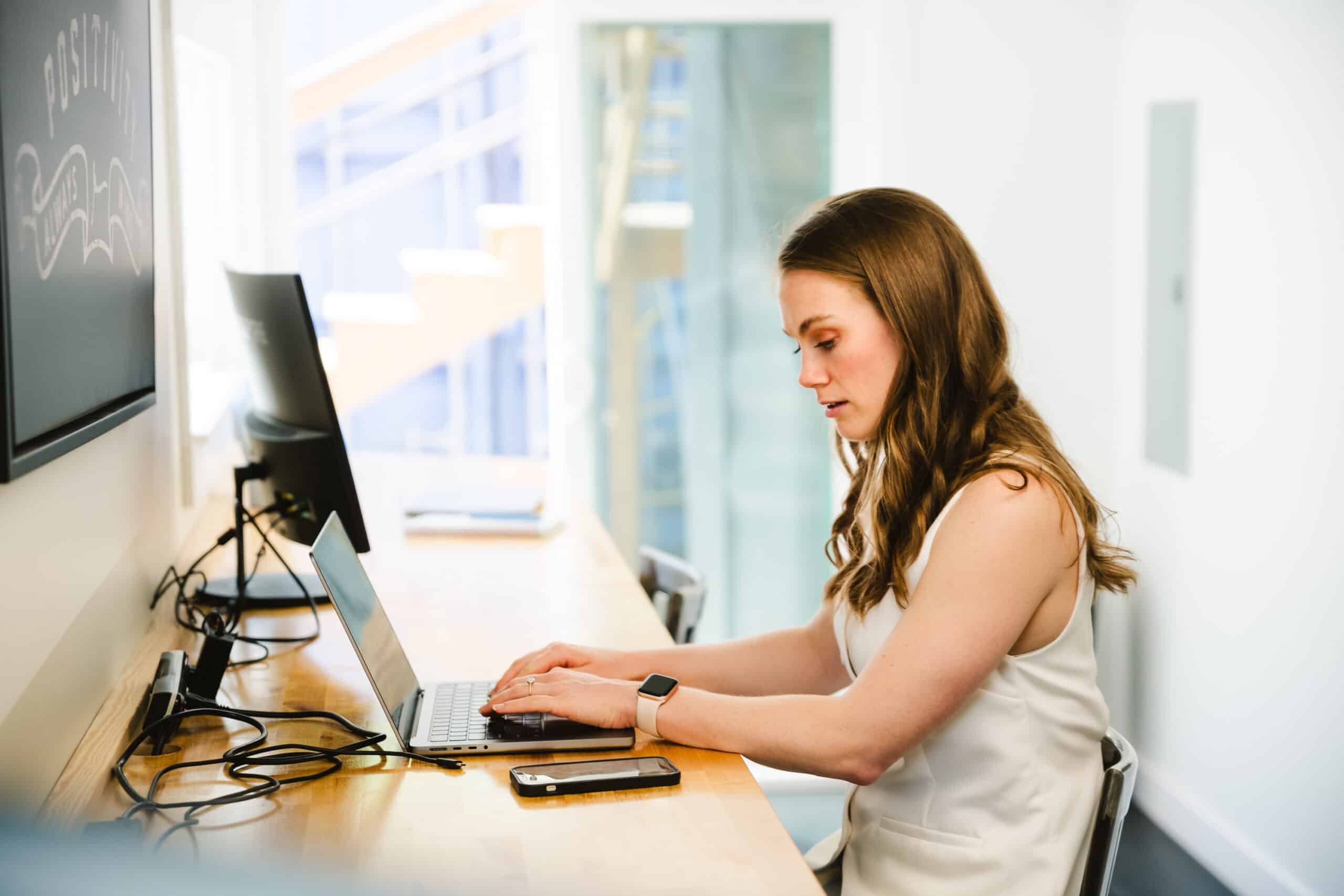 A warehouse supervisor uses her computer to track employee performance