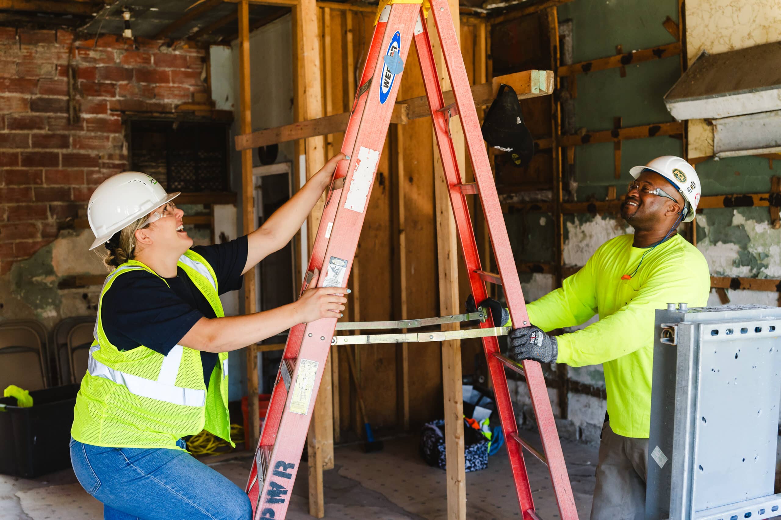 Two Millwrights work together to reach machinery that needs attention