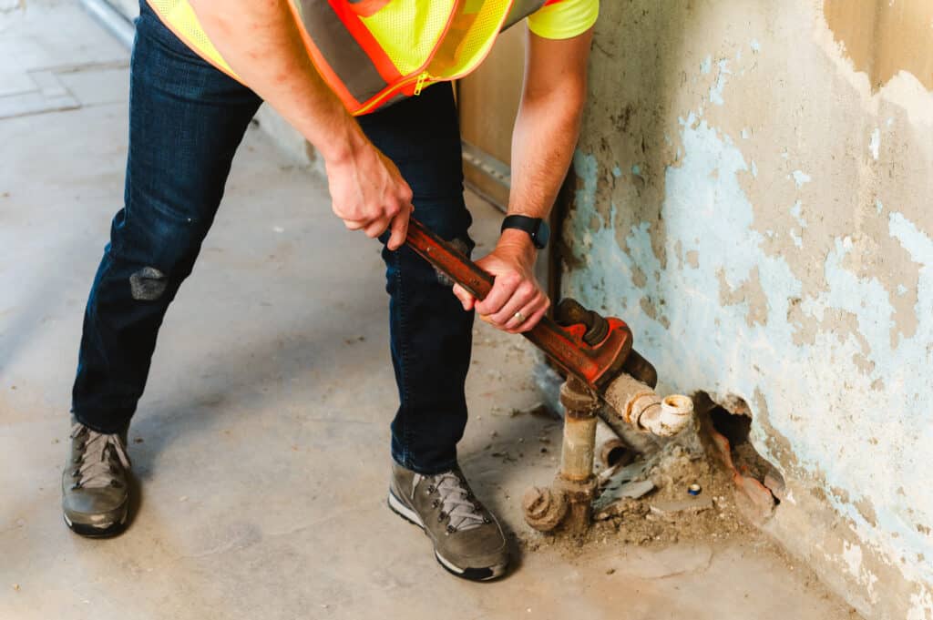 A plumber works on a job site