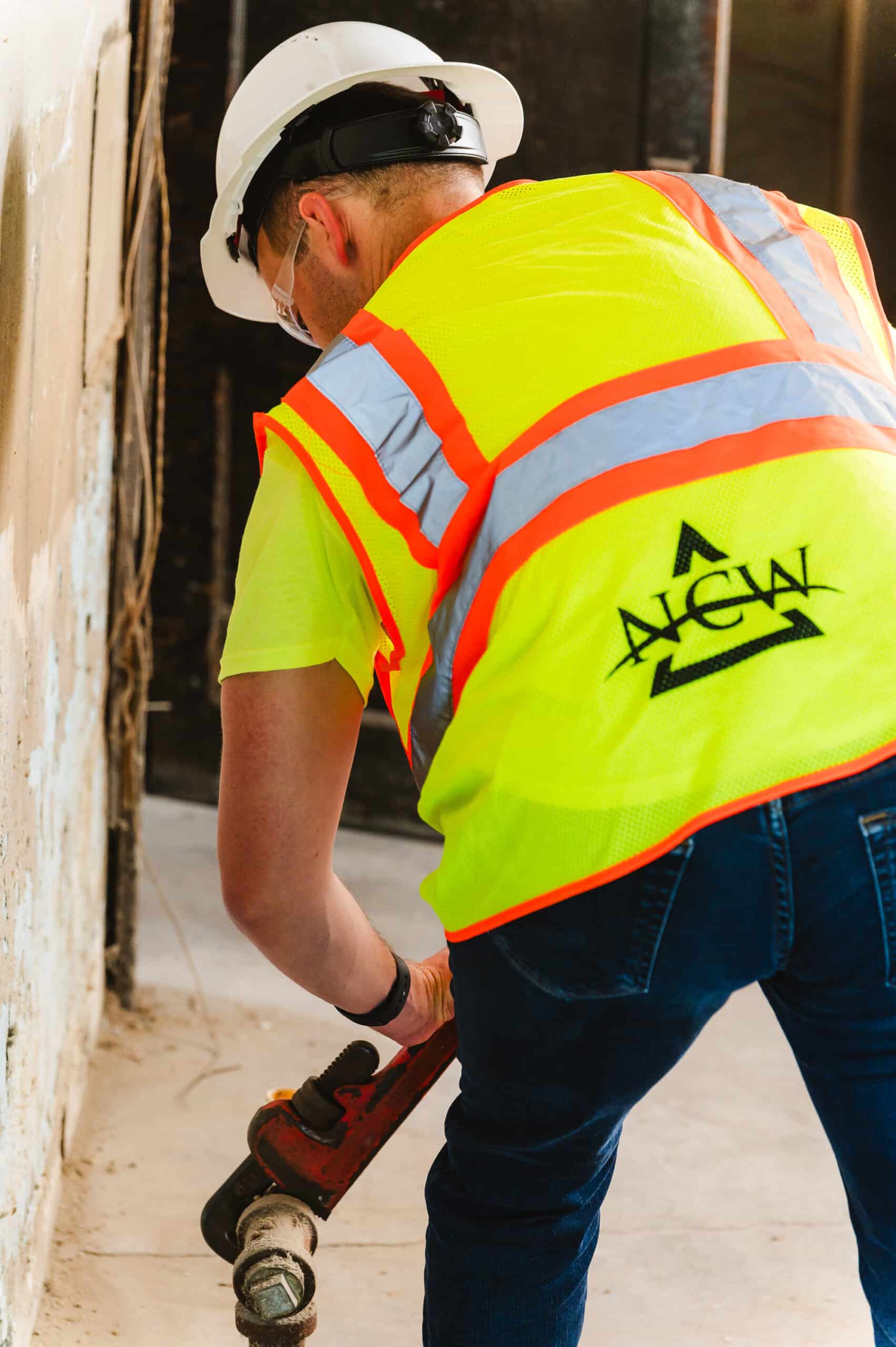 An NCW construction laborer works on a job site's plumbing