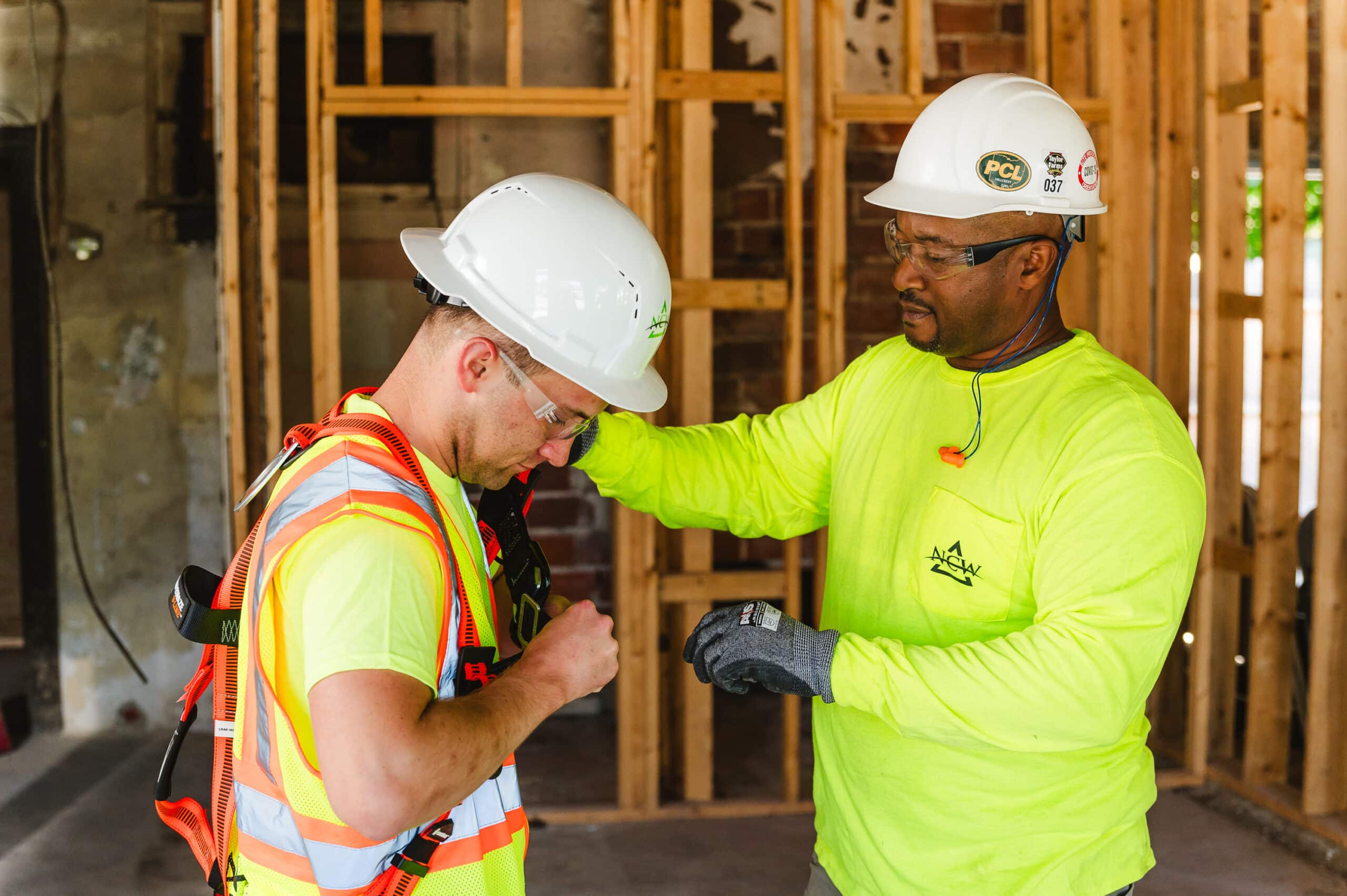 Two construction workers conduct a safety check to ensure proper safety protocols and equipment use.