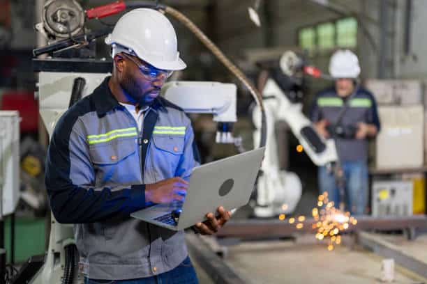 Mechanical engineer working for maintenance or repairing robotic welding machine in factory. Maintenance and repairing work in modern industry concept.